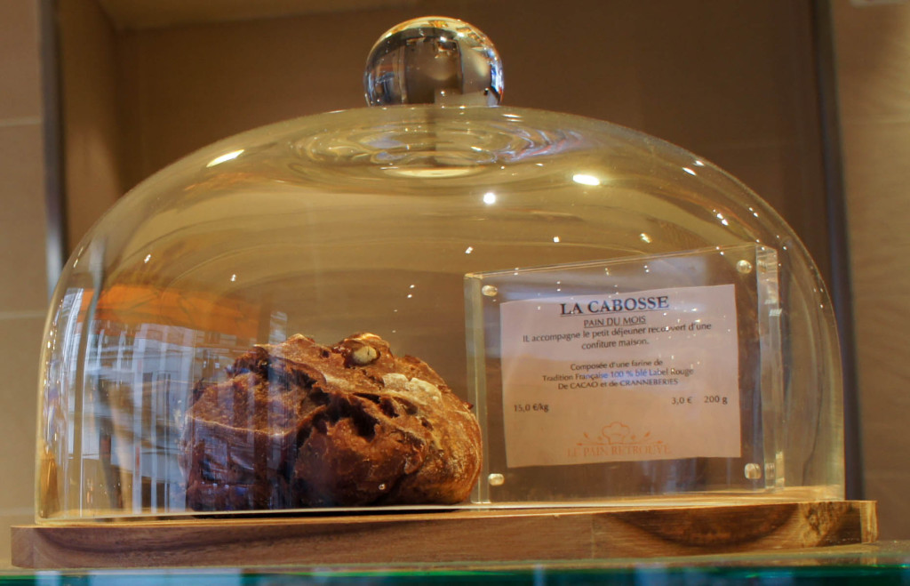 Le pain du mois, La Cabosse, au cacao et cranberries, présenté sous cloche.